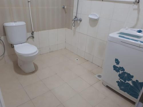 a bathroom with a toilet and a sink at Discovery Furnished Apartments (Al-Amerat) in Sayḩ adh Dhabi