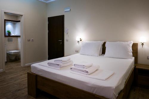 um quarto com uma grande cama branca com toalhas em Shahbazian House em Plovdiv