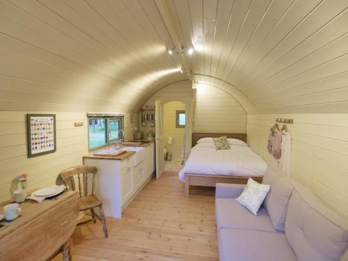 ein Schlafzimmer mit einem Bett und einem Waschbecken in einem Zimmer in der Unterkunft Orchard Farm Luxury Glamping in Glastonbury