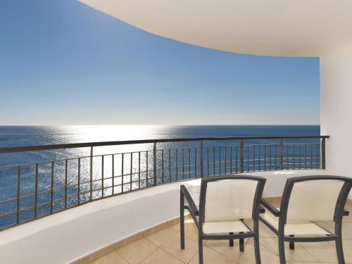 een balkon met stoelen en uitzicht op de oceaan bij Olée Nerja Holiday Rentals by Fuerte Group in Torrox Costa