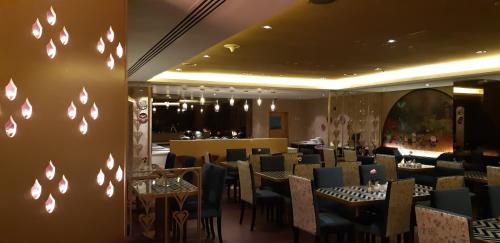 ein Restaurant mit Tischen und Stühlen in einem Raum in der Unterkunft Lotus Grand Hotel in Dubai