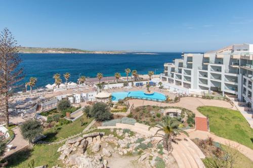 an aerial view of a hotel and the ocean at Dolmen Hotel Malta in St. Paul's Bay