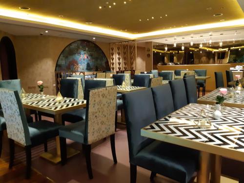 a restaurant with long tables and blue chairs at Lotus Grand Hotel in Dubai
