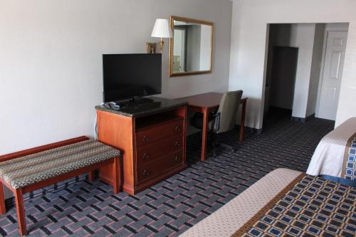 una camera d'albergo con scrivania, TV e letto di The Lion Inn - Saint Augustine a St. Augustine
