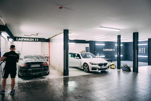 a man standing in a garage with two cars at BOUTIQUE HOTEL11 with rooftop SPA in Nitra