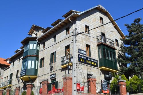 a large building with a clock on the top of it at Hostal Aribel Longinos in Cercedilla