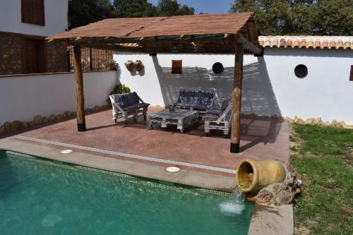 a patio with a gazebo and a swimming pool at Casa Fraskito in Iznájar