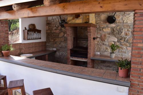 an outdoor bar with a stone fireplace at Casa Fraskito in Iznájar