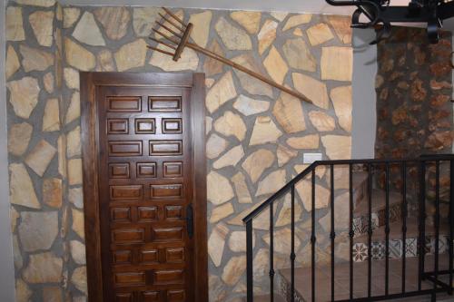 a room with a door and a stone wall at Casa Fraskito in Iznájar