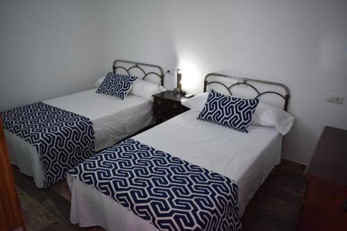 two beds sitting next to each other in a room at Casa Fraskito in Iznájar