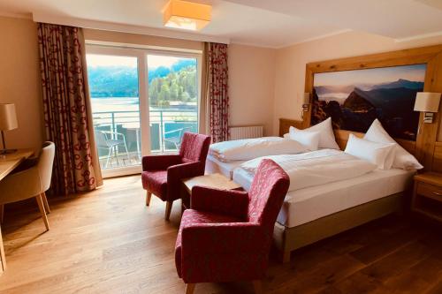 a hotel room with a bed and a large window at Seevilla Altaussee in Altaussee