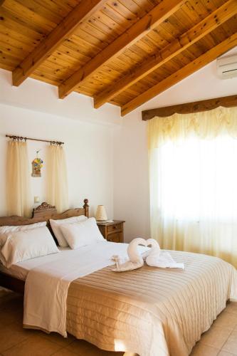 a bedroom with a large bed with towels on it at Plakalona Apartments in Exopoli