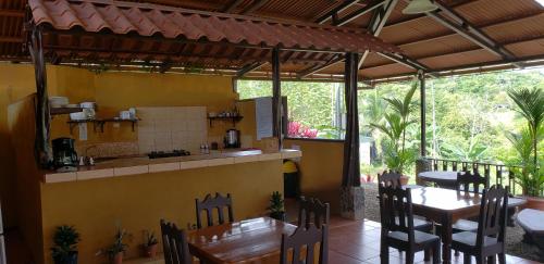 a restaurant with a kitchen and tables and chairs at Cabinas Pura Vida B&B and Tour Operator in Drake