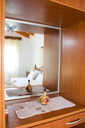 a mirror in a room with a bed and a bedroom at Plakalona Apartments in Exopoli