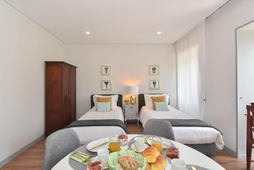 a hotel room with two beds and a table with food on it at Rosario's Boutique Apartments in Porto
