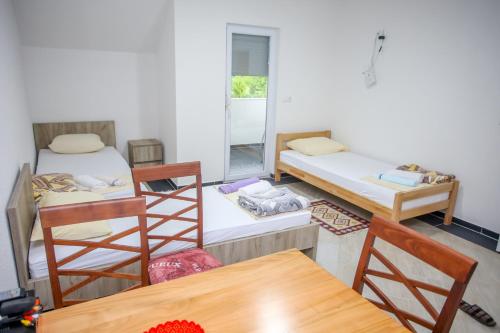 a room with three beds and a table and chairs at Apartments River Una 4 in Bihać