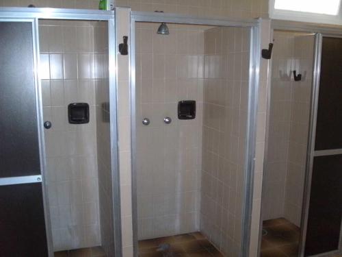 una ducha con puerta de cristal en un baño en Apartamento Gigante, pé na areia, en Guarujá