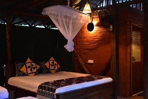 a bedroom with a bed with a net at Lizard Safari Lodge in Udawalawe