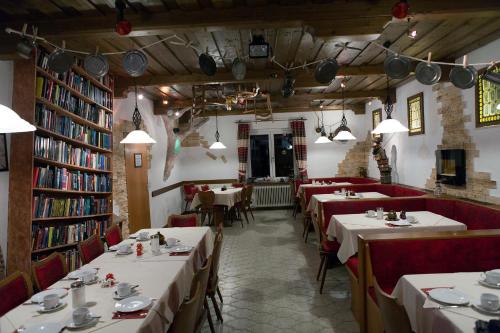 ein Restaurant mit Tischen und Stühlen in einer Bibliothek in der Unterkunft Hotel zum Zauberkabinett in Bad Heilbrunn