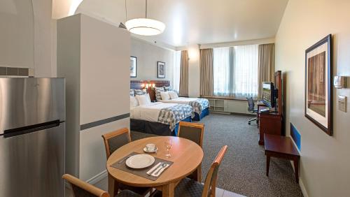 a hotel room with a table and a bed at Le Square Phillips Hôtel & Suites in Montréal