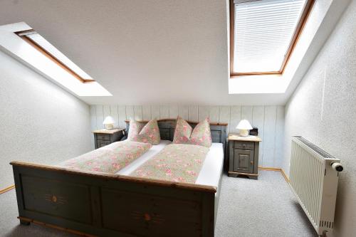 a bedroom with a bed with pink pillows and a window at Ferienwohnungen Bloier in Bad Birnbach
