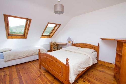 a bedroom with two beds and a table and window at Rainbow hostel in Dingle