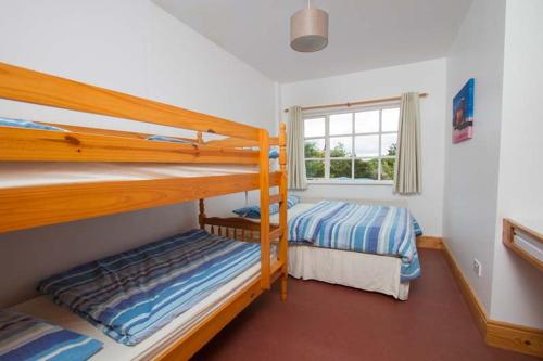 a bedroom with two bunk beds and a window at Rainbow hostel in Dingle