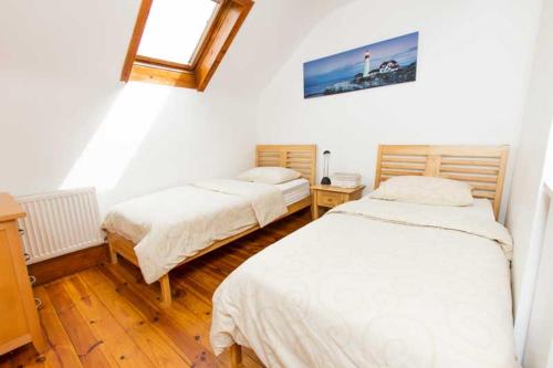 een slaapkamer met 2 bedden en een raam bij Rainbow hostel in Dingle