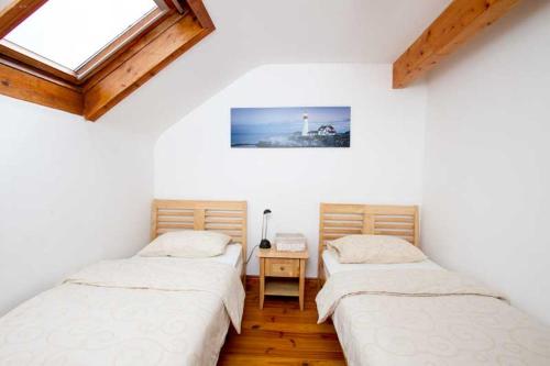 two twin beds in a room with a lighthouse at Rainbow hostel in Dingle