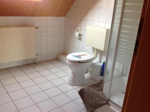 ein kleines Bad mit einem WC und einer Dusche in der Unterkunft Ferienwohnungen Walter in Cuxhaven