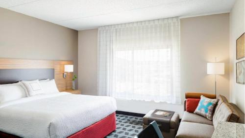 a hotel room with a bed and a couch at TownePlace Suites by Marriott Portland Beaverton in Beaverton