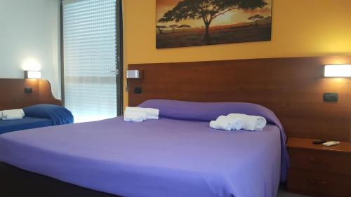 a bedroom with a large bed with towels on it at Residenza Teodolinda in Monza