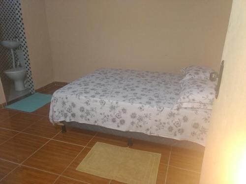 a small bed in a room with a floor at Hospedagem Amanhecer in Barreirinhas