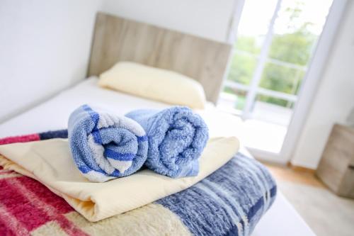 a bed with blue towels on top of it at Villa River Una 6 in Bihać