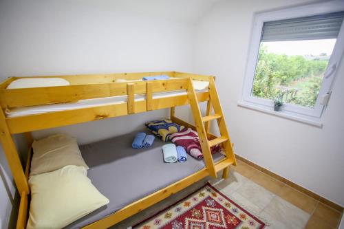 a bunk bed in a room with a window at Villa River Una 6 in Bihać