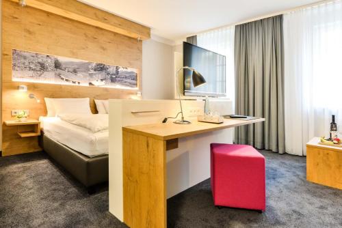a hotel room with a desk and a bed at Hotel Restaurant Sonne in Gengenbach