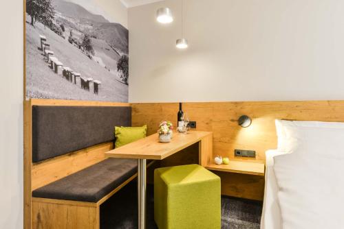 a room with a table and a bench and a bed at Hotel Restaurant Sonne in Gengenbach