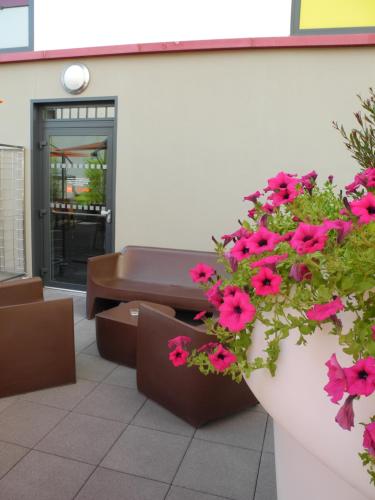 a patio with a couch and flowers in front of a building at Apparthotel Privilodges Carré de Jaude in Clermont-Ferrand
