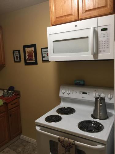 a white stove top oven sitting next to a microwave at Economy Guest Village in Rock Springs