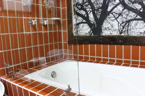 a bath tub in a tiled bathroom with a window at Finca Campestre La Adelita B&B in Salento