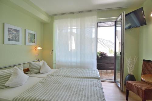 a bedroom with two beds and a sliding glass door at Weinhaus Thomas in Klotten