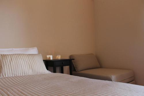 a bedroom with a bed and a chair at Convento di San Colombo in Santo Stefano di Sessanio