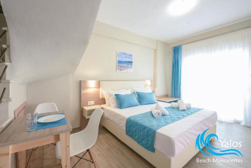 a hotel room with a bed and a desk and a desk at Yalos Beach Maisonettes in Skala Sotiros