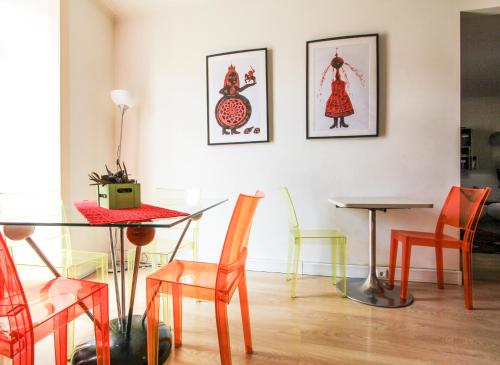 a table and chairs in a room with paintings on the wall at Evora Inn in Évora