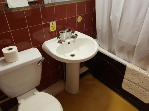 a white toilet sitting next to a sink in a bathroom at The County Hotel in Carlisle