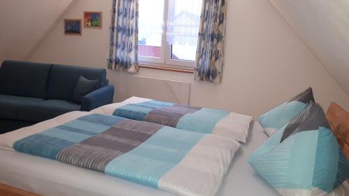 a bedroom with a bed and a chair and a window at Ferienhäuser May in Weigenheim