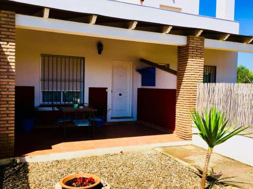 a small house with a patio with a table at Los Candiles in Conil de la Frontera