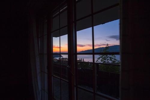 a view of a sunset from a window at B&B Haussener in Krattigen