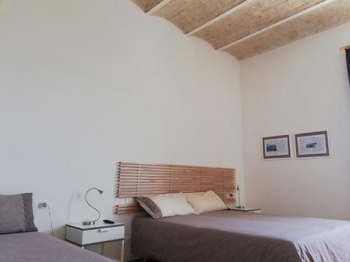 a bedroom with two beds and a wooden headboard at Agriturismo Masseria Cannella in Lesina
