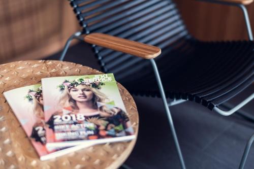 a magazine sitting on a table next to a chair at Conrad's Mountain Lodge in Silvaplana
